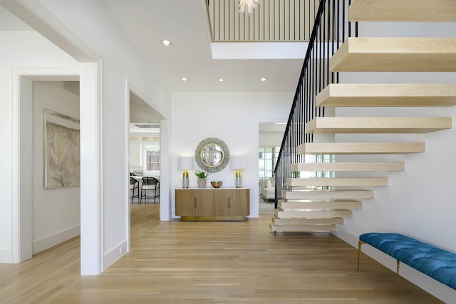 stairs featuring wood finished floors, plenty of natural light, and recessed lighting