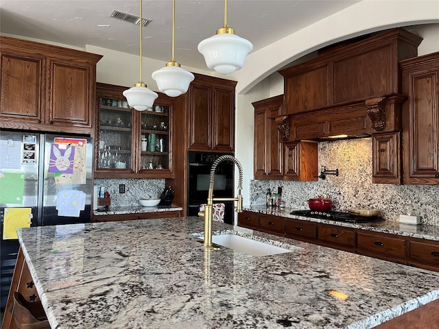 kitchen with tasteful backsplash, visible vents, a sink, and black appliances