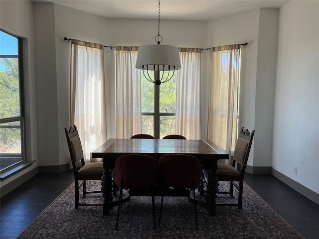 dining area with dark wood-style flooring and baseboards