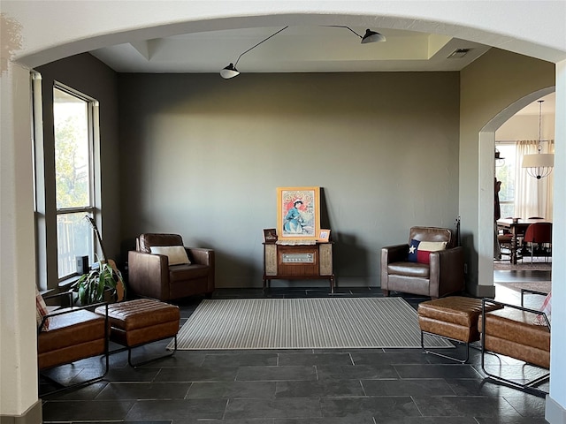 sitting room featuring a wealth of natural light, arched walkways, and visible vents