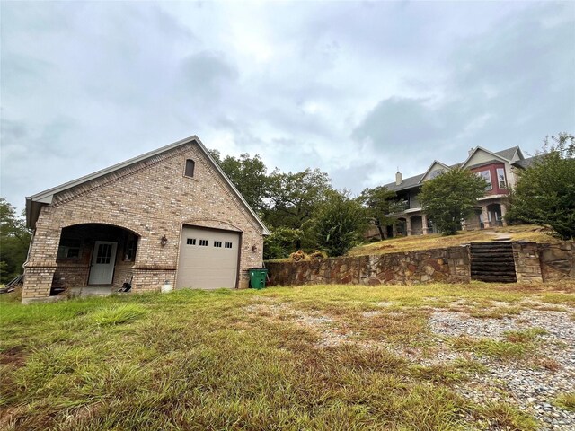view of property exterior featuring brick siding and a garage
