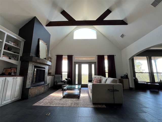 living room with arched walkways, a tile fireplace, high vaulted ceiling, and visible vents
