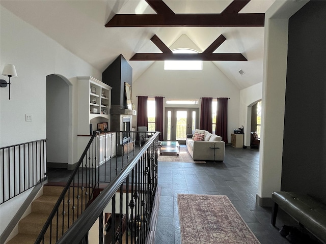 corridor with beamed ceiling, high vaulted ceiling, arched walkways, and visible vents