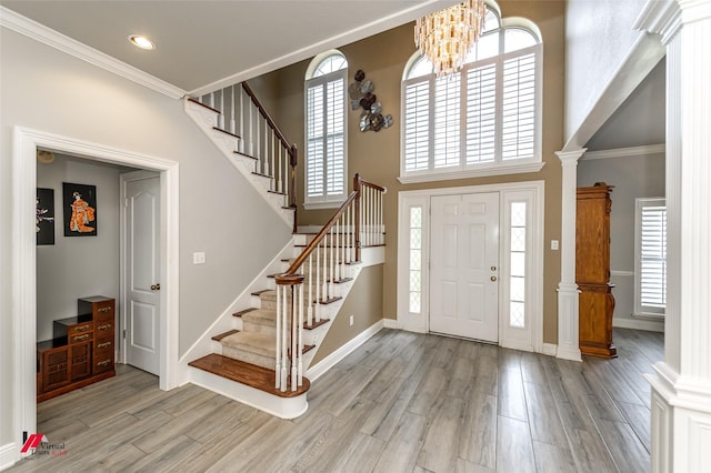 1231 Whitehall Dr, Bossier City, LA 71112 - foyer featuring light wood finished floors, a notable chandelier, decorative columns, and stairs