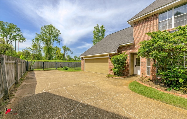 1231 Whitehall Dr, Bossier City, LA 71112 - view of home's exterior with brick siding, fence, a garage, and driveway