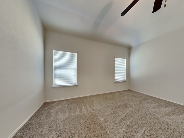 carpeted empty room with baseboards, a ceiling fan, and a healthy amount of sunlight