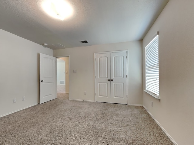 unfurnished bedroom featuring visible vents, baseboards, and carpet flooring