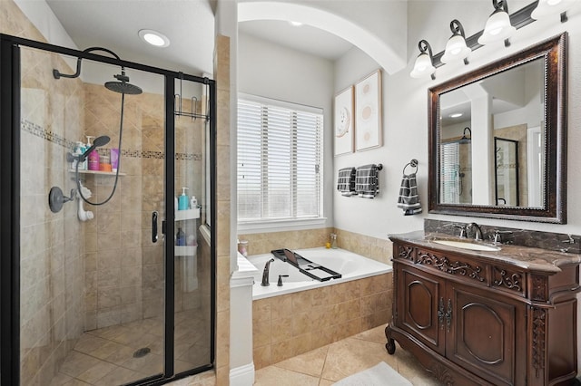 full bath featuring tile patterned floors, vanity, a bath, and a stall shower