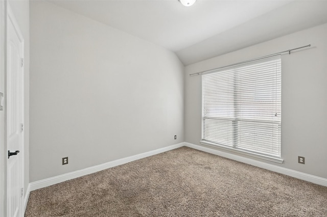 spare room featuring lofted ceiling, baseboards, and carpet floors