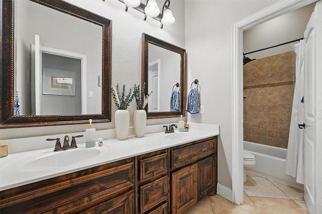 full bath with tile patterned flooring, double vanity, a sink, and toilet