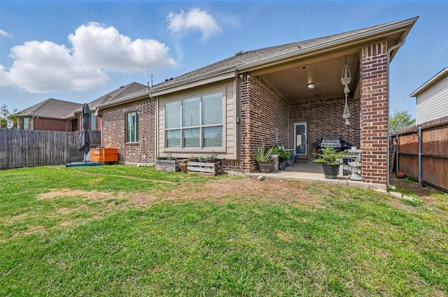 back of house with brick siding and a fenced backyard
