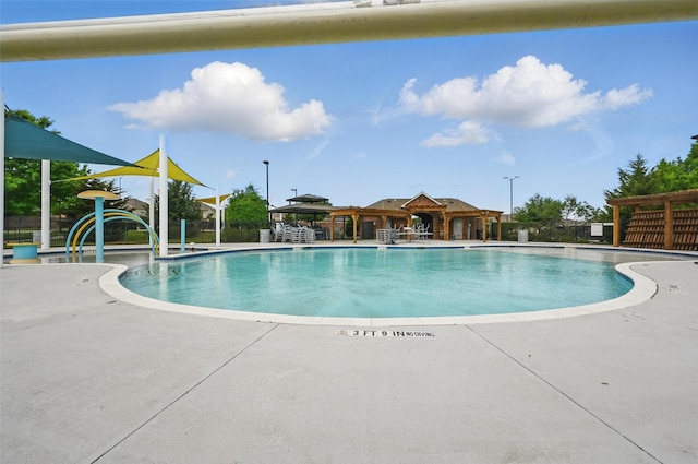 pool with a patio area and fence