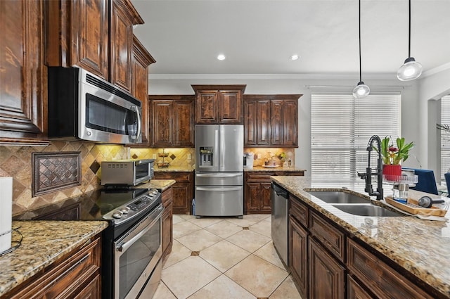 kitchen with a toaster, crown molding, decorative light fixtures, appliances with stainless steel finishes, and a sink
