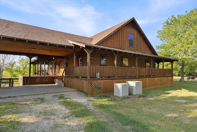 view of side of property featuring an attached carport, central AC unit, driveway, and board and batten siding