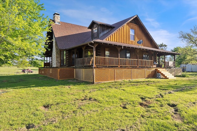 back of house with roof with shingles, a chimney, board and batten siding, a yard, and covered porch