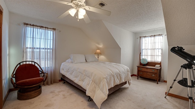 bedroom featuring ceiling fan, a textured ceiling, visible vents, light carpet, and baseboards