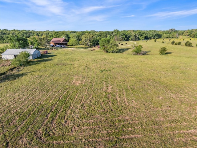 view of yard featuring a pole building, an outdoor structure, and a rural view