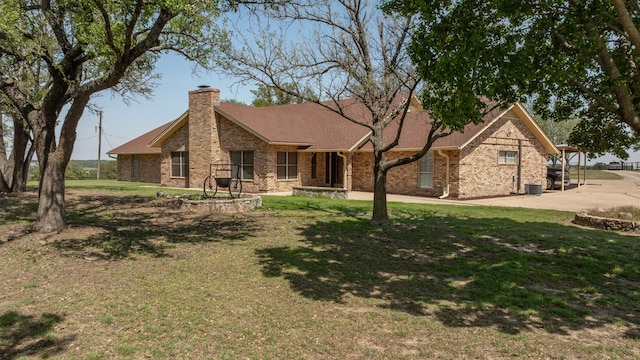 ranch-style house with a front yard, brick siding, a chimney, and central AC unit