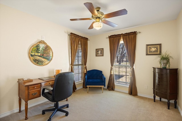 office space featuring light carpet, baseboards, and ceiling fan