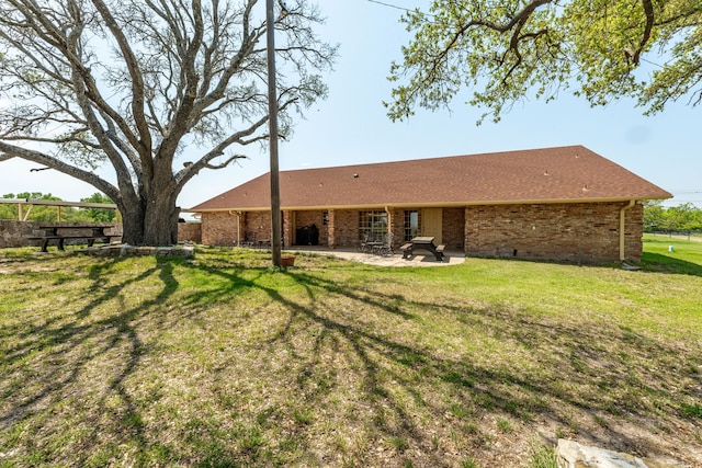 back of property with a patio, a yard, fence, and brick siding