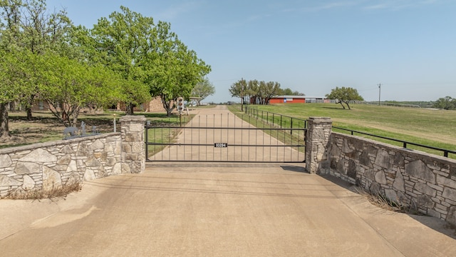 view of gate with a yard