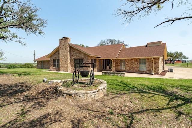 view of front of property featuring brick siding, a chimney, and a front lawn