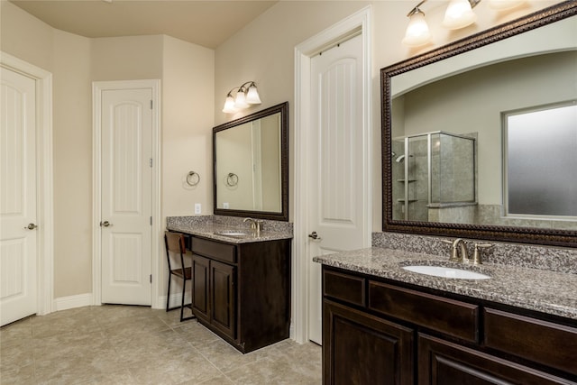 bathroom featuring two vanities, tile patterned floors, a stall shower, and a sink