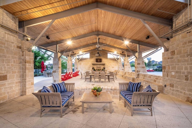 view of patio with a gazebo, an outdoor living space with a fireplace, and outdoor dining space