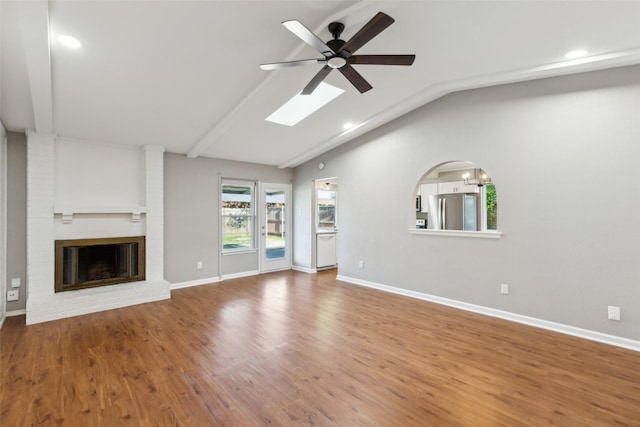 1001 Roaring Springs Dr, Allen, TX 75002 - unfurnished living room featuring vaulted ceiling, a brick fireplace, a ceiling fan, wood finished floors, and baseboards