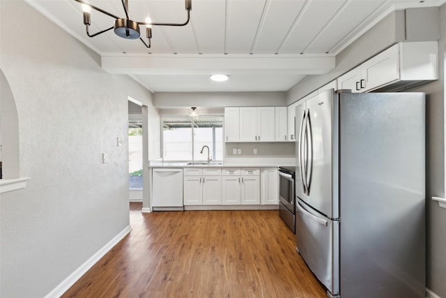 1001 Roaring Springs Dr, Allen, TX 75002 - kitchen featuring appliances with stainless steel finishes, a sink, white cabinetry, light wood-style flooring, and light countertops
