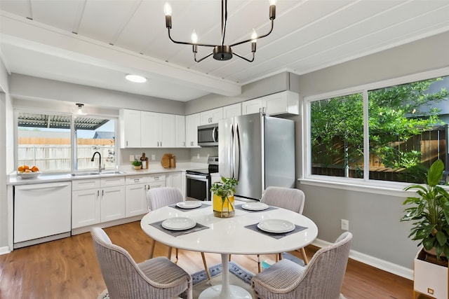 1001 Roaring Springs Dr, Allen, TX 75002 - dining area featuring a chandelier, healthy amount of natural light, light wood-type flooring, baseboards, and beam ceiling
