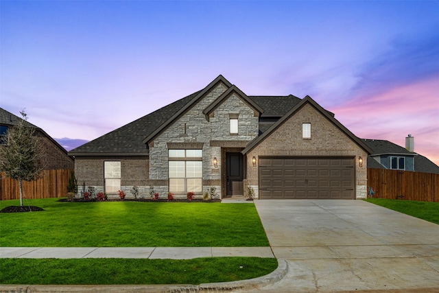 french country inspired facade featuring a front yard, fence, a shingled roof, and concrete driveway
