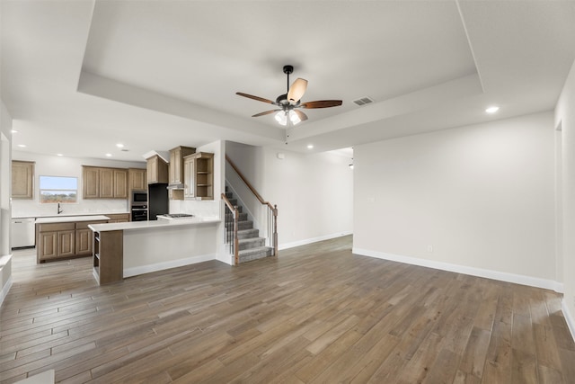 unfurnished living room featuring light wood finished floors, ceiling fan, stairs, and recessed lighting