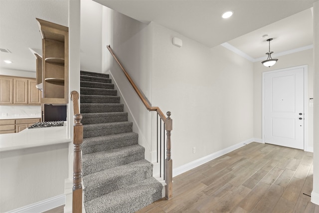 foyer with crown molding, recessed lighting, stairs, light wood finished floors, and baseboards