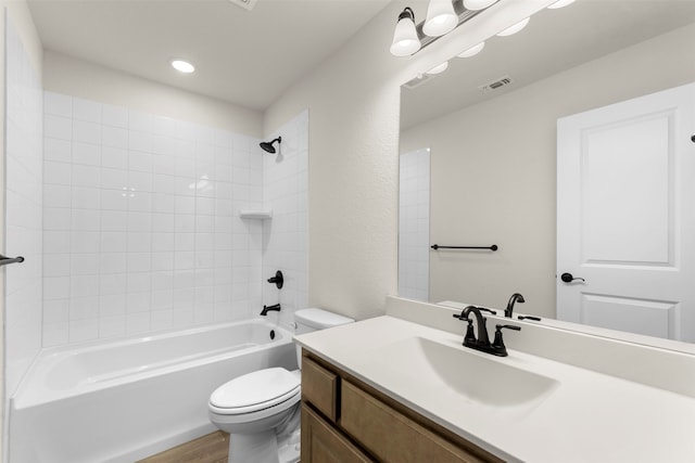 bathroom with vanity, toilet, visible vents, tub / shower combination, and wood finished floors