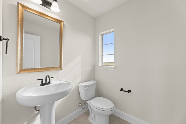 half bathroom featuring toilet and baseboards
