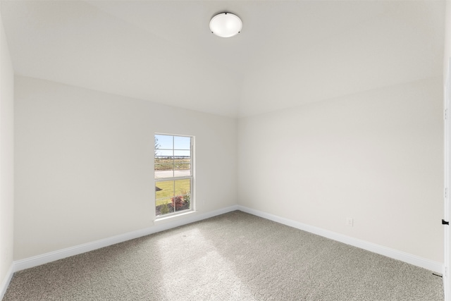spare room featuring baseboards, carpet flooring, and vaulted ceiling