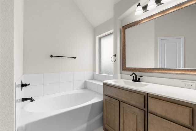 full bathroom featuring vanity, vaulted ceiling, and a garden tub