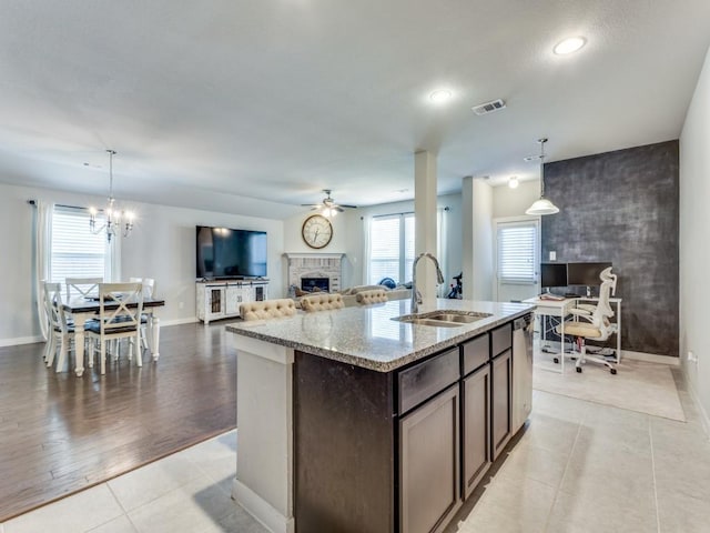 1116 Fulbourne Dr, Anna, TX 75409 - kitchen featuring a sink, a ceiling fan, dark brown cabinetry, a brick fireplace, and open floor plan