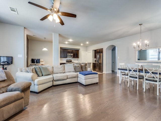 1116 Fulbourne Dr, Anna, TX 75409 - living area with arched walkways, dark wood-style flooring, a ceiling fan, a chandelier, and recessed lighting