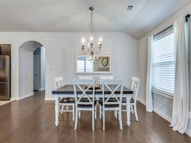 1116 Fulbourne Dr, Anna, TX 75409 - dining area with arched walkways, a chandelier, wood finished floors, baseboards, and vaulted ceiling