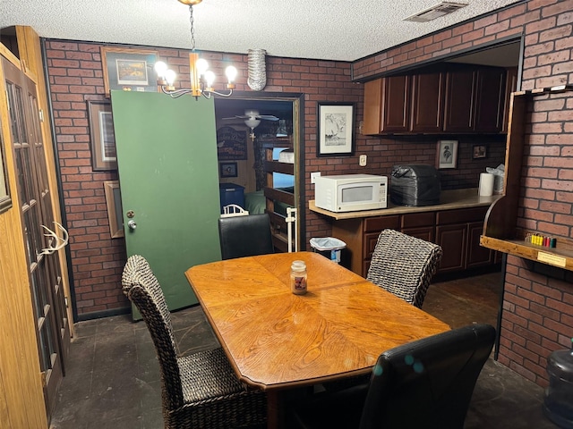 15095 US Highway 82 E, No City, TX 76380 - dining room with brick wall, visible vents, and ceiling fan with notable chandelier