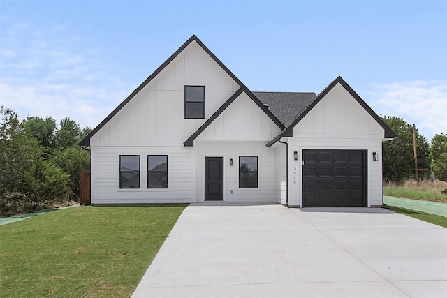 modern inspired farmhouse featuring an attached garage, board and batten siding, a front yard, and concrete driveway