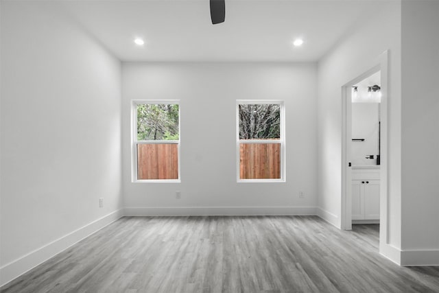 empty room with baseboards, recessed lighting, ceiling fan, and wood finished floors