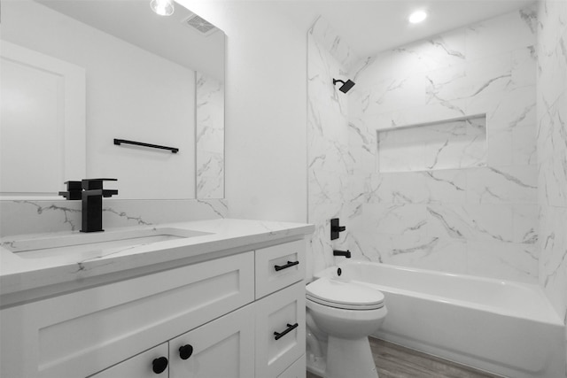 bathroom featuring bathtub / shower combination, vanity, toilet, wood finished floors, and visible vents
