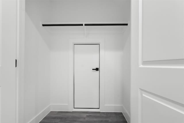 spacious closet with dark wood-style floors