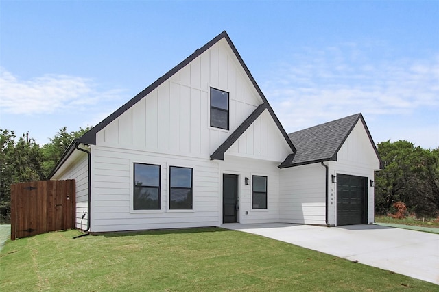modern inspired farmhouse with an attached garage, board and batten siding, concrete driveway, and a front lawn