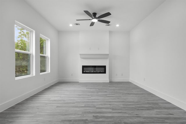 unfurnished living room featuring visible vents, recessed lighting, a glass covered fireplace, and ceiling fan