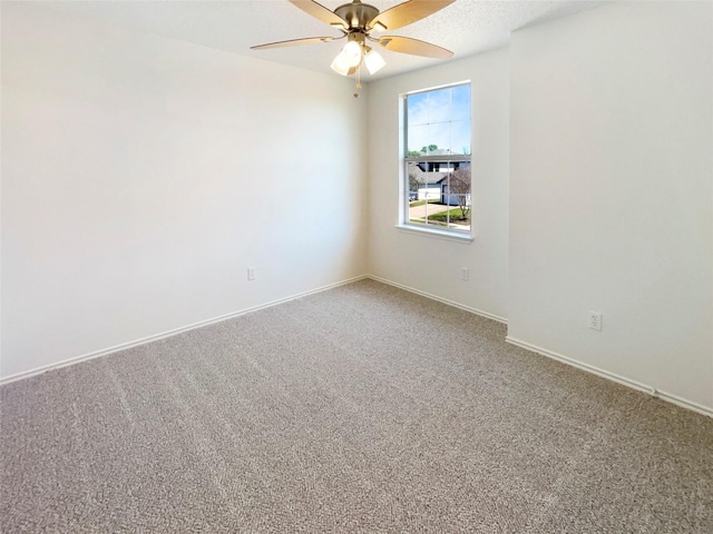spare room with carpet flooring, baseboards, and a ceiling fan