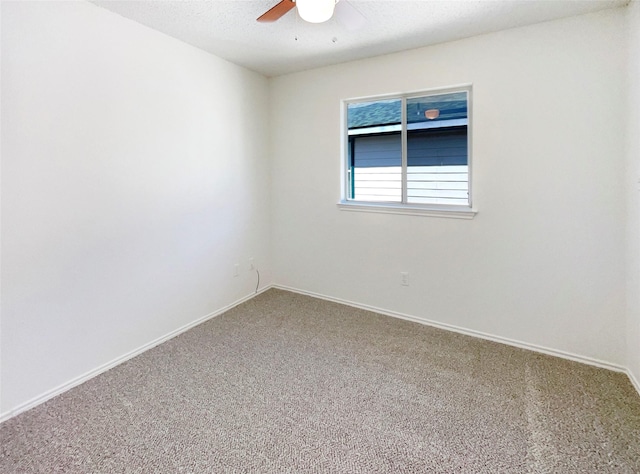 carpeted empty room featuring baseboards and a ceiling fan